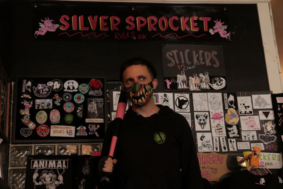 Avi Ehrlich stands with a striped pink baseball bat within his store on Valencia Street.