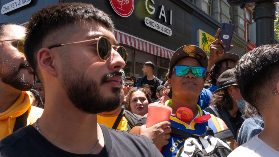 A crowd of Warriors fans look at the parade.