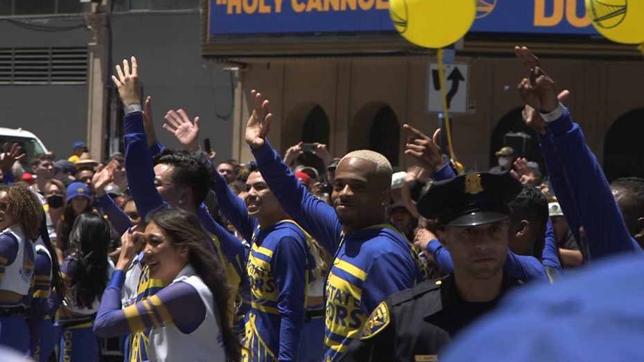 Warriors cheerleaders wave at the crowd during the parade.