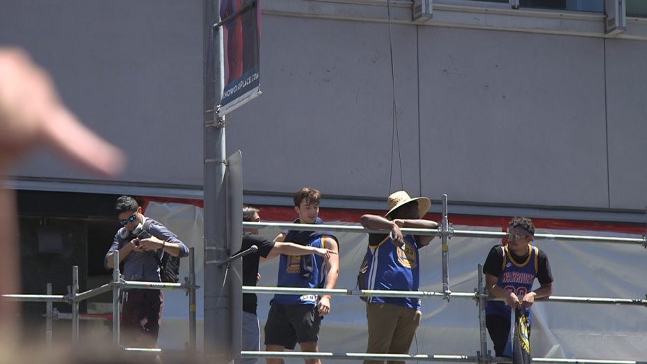 ans stand on top of a scaffolding for a good view of the Parade