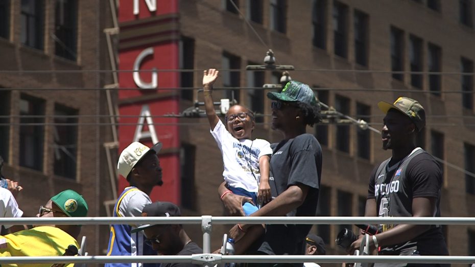 Jonathan Kuminga waves to the crowd at the Warriors parade.