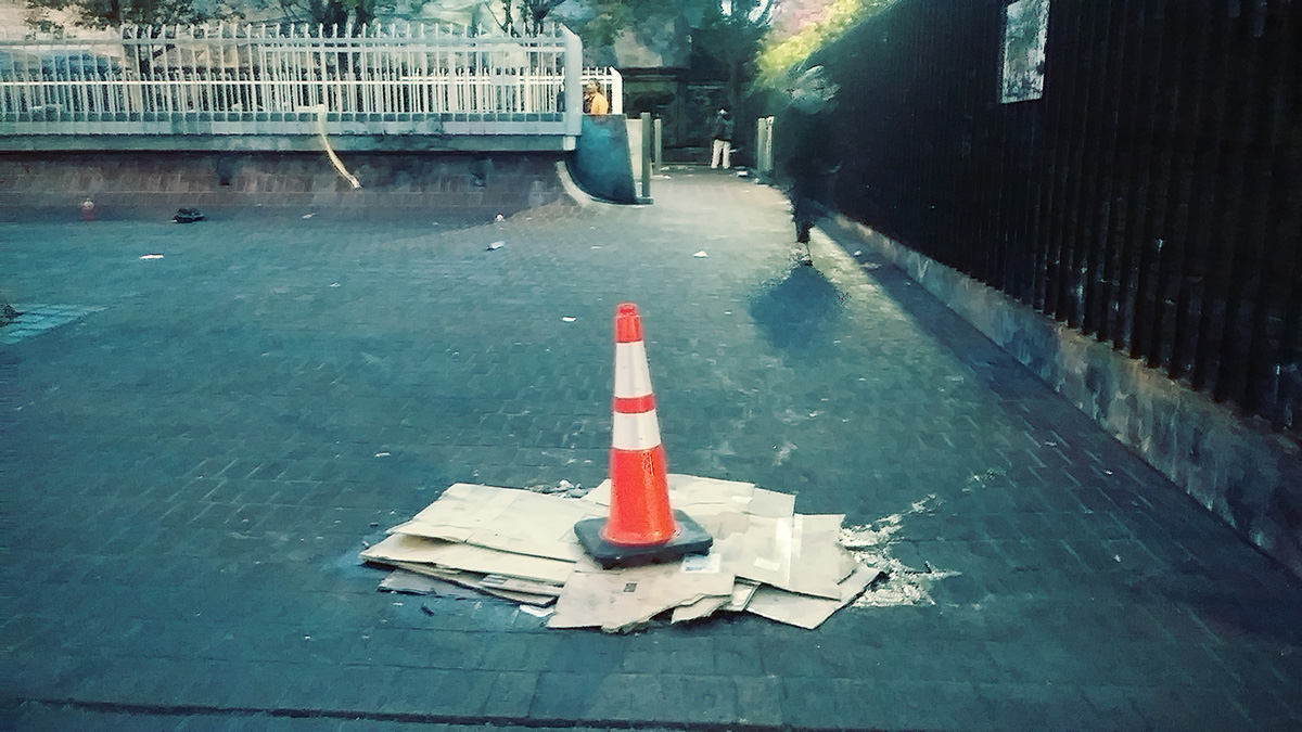 Cardboard and a traffic cone cover a drain at 24th Street Mission.