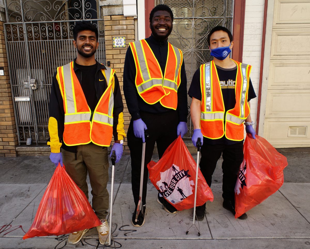A photo of three people with garbage bags.