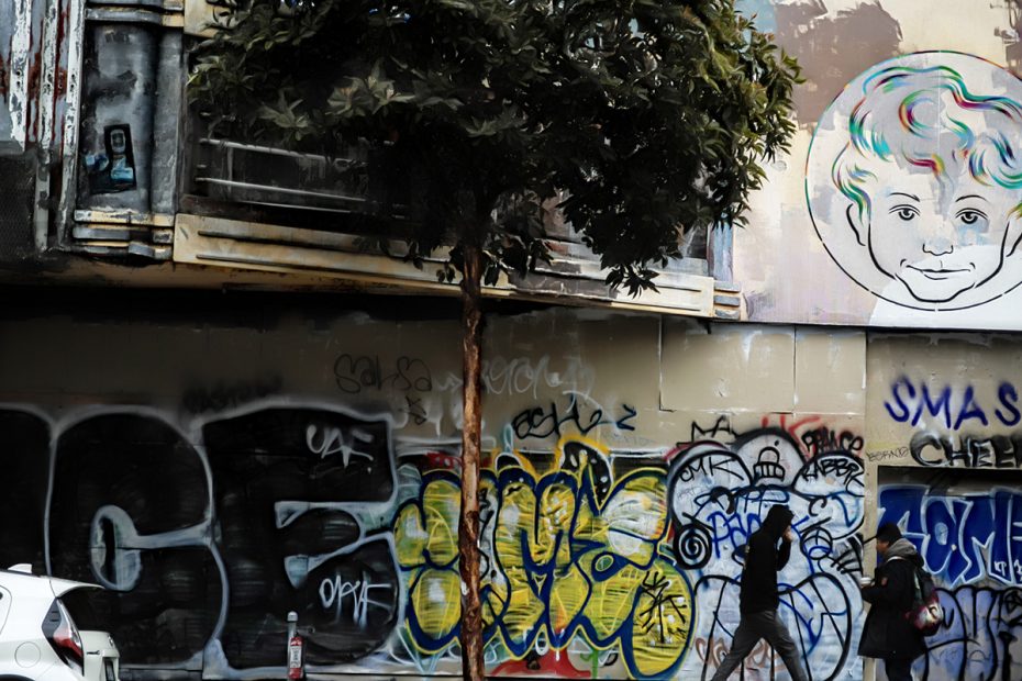 Graffiti and figures on an old cinema facade.
