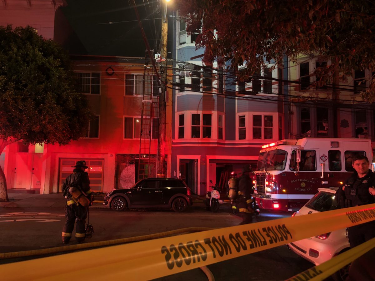 A fireman in front of a building with caution tape in front.