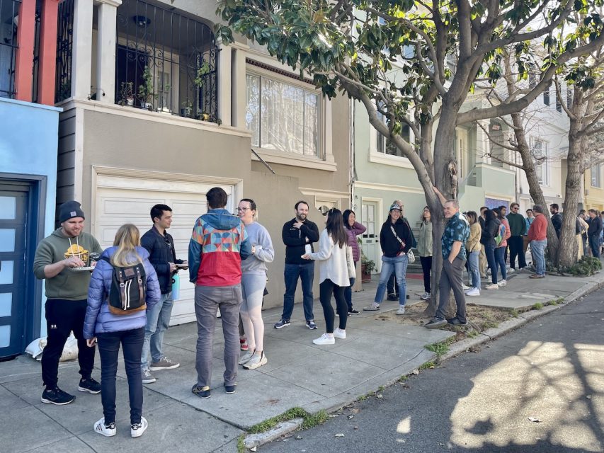 People lining the sidewalk in long lines