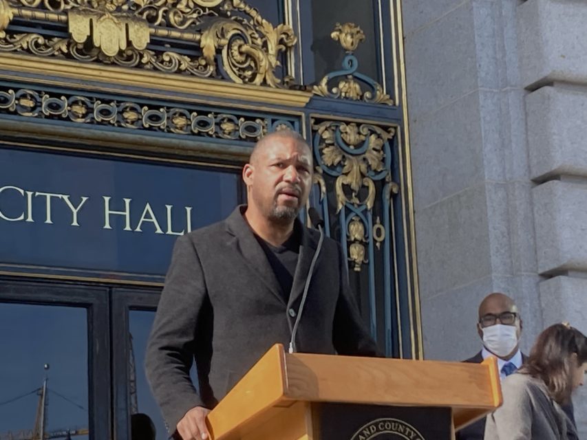 A man speaks at a podium at City Hall
