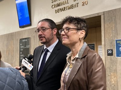 A man and a woman speak into microphones