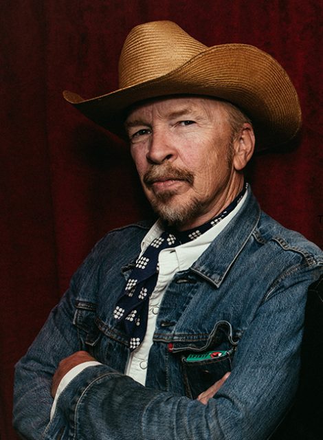 A man with a hat and tie, white shirt from the chest up. 
