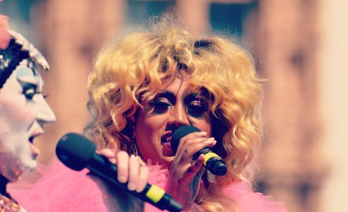 Two people in drag with microphones.