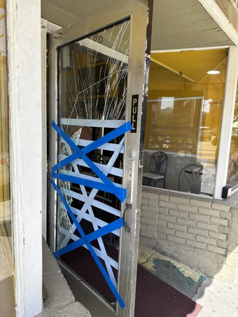 Smashed glass door with painters' tape affixed across it