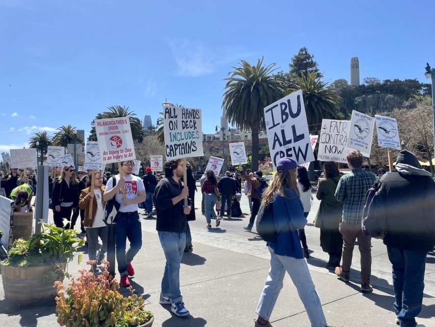 A group of Alcatraz Cruises workers walking with signs
