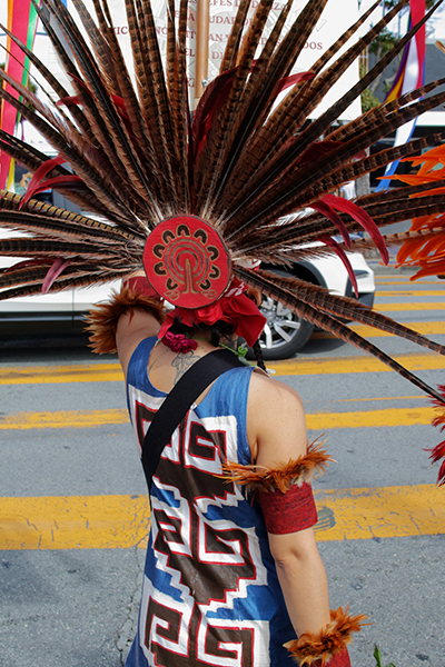 An Aztec dancer from the back with a large headdress.