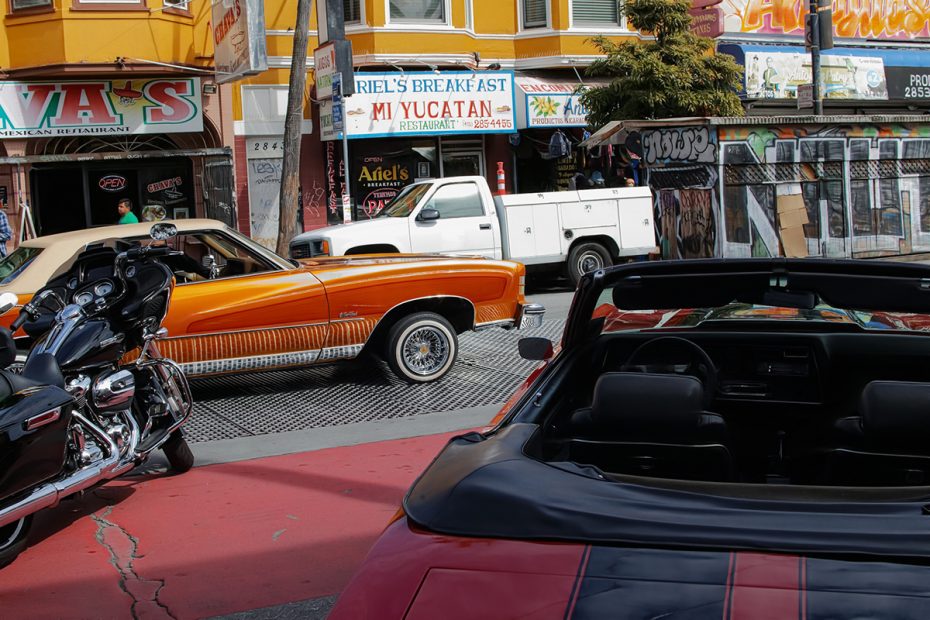 A lowrider. Orange with a convertible top that is closed.