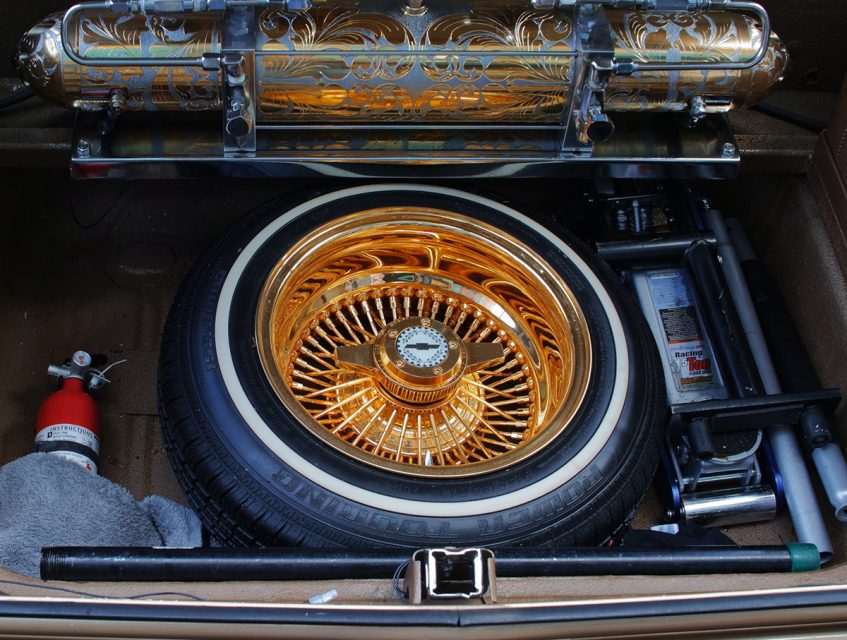A gold hubcap on a wheel.