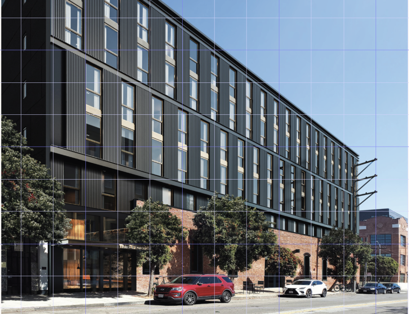 A three-story building with a lot of glass and a couple of cars parked in front. 