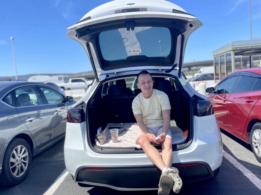 A person sitting in the trunk of a car