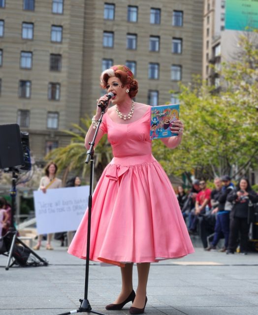 A drag performer read from a book called The Hips of the Drag Queen Go Swish Swish Swish.