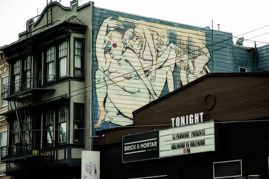 A mural of love making on the side of a house.