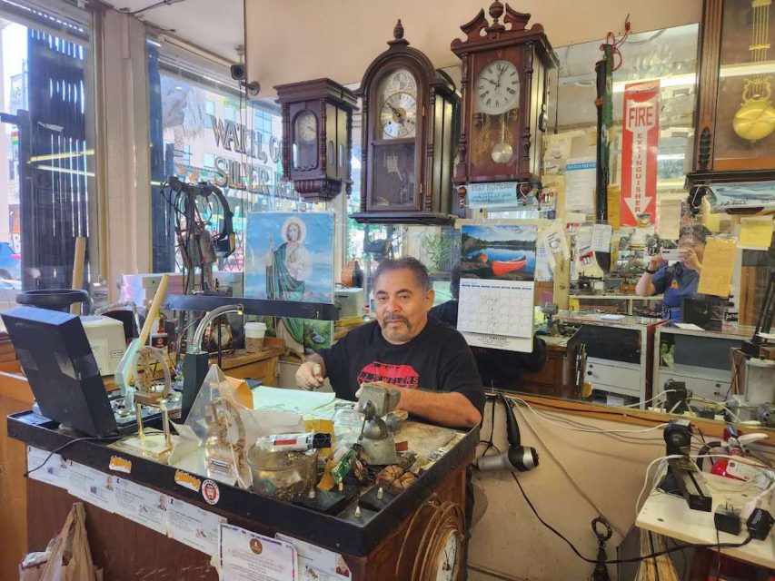 a man sitting next to clocks
