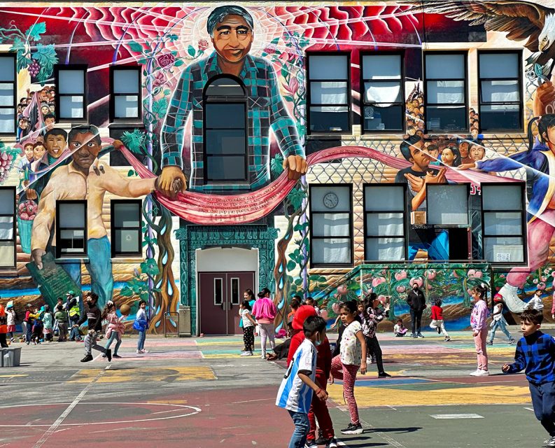 A big mural overlooking a playground where children are playing.