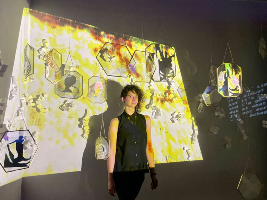 A person standing in front of a colorful background.