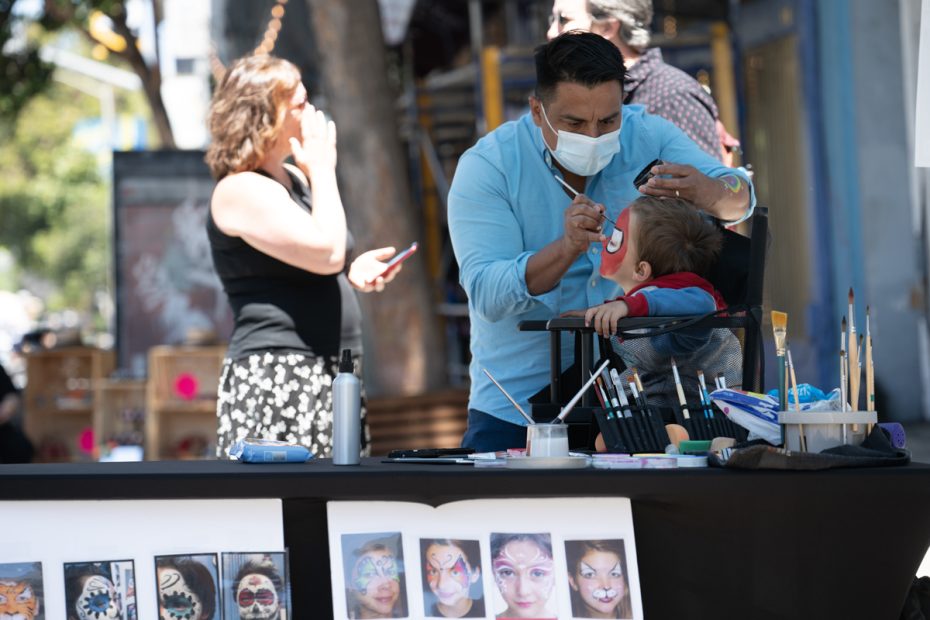 Two people getting their faces painted.