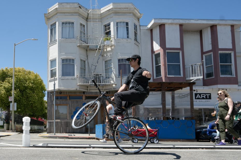 someone doing a wheelie in the middle of the streets.