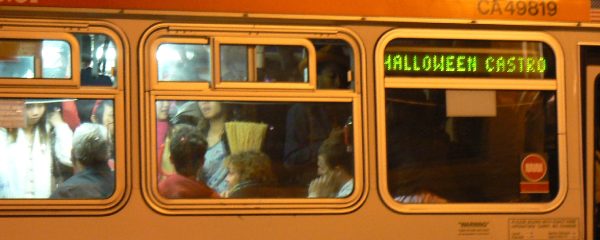 An orange bus peeks at Halloween revelers.