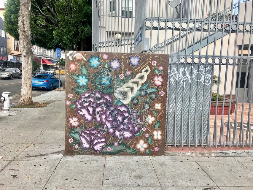 A large board with stars and circles leaning against a grated fence.