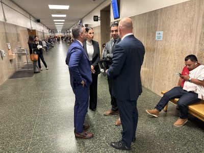 Saam Zanganeh, Bradford Cohen, Tony Brass and Zoe Aron huddled together in a court hallway during the second day of Nima Momeni's preliminary hearing.