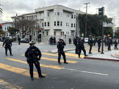 San Francisco police officers lined up at the intersection of 19th and Dolores streets during the shutdown of the hill bomb.