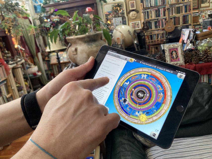 A tablet shows an astrology app