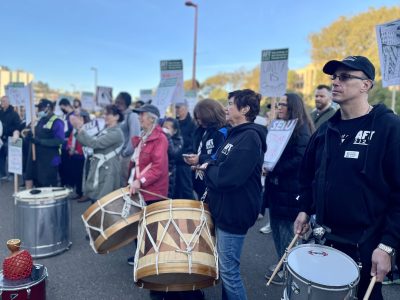 A group of people from CCSF holding drums on a street.