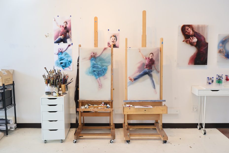 Three easels with paintings on them in an art studio.