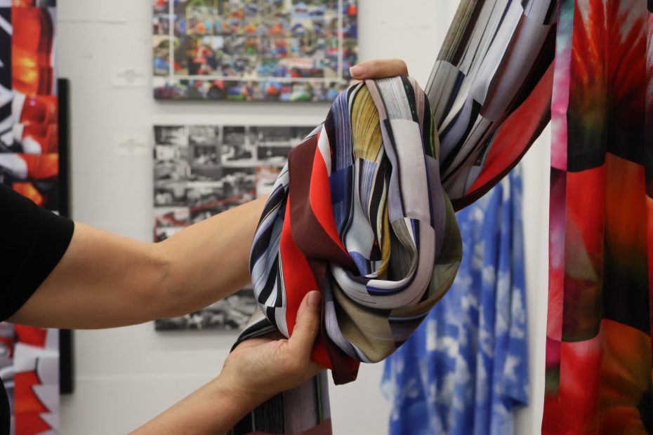 A person holding a patterned silk scarf.