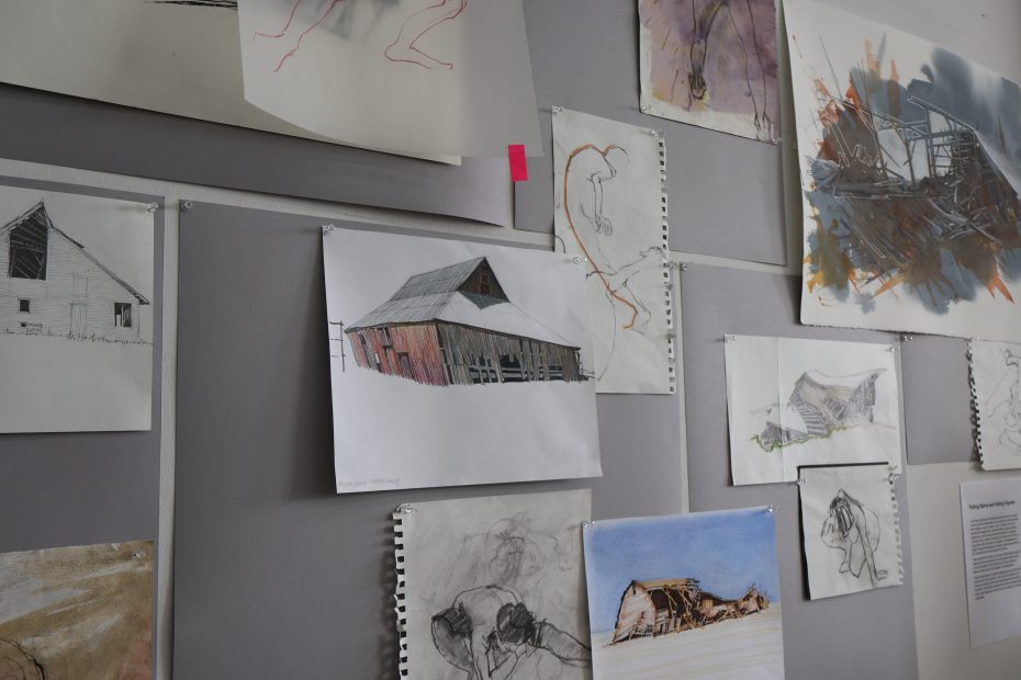 A group of drawings on a wall.