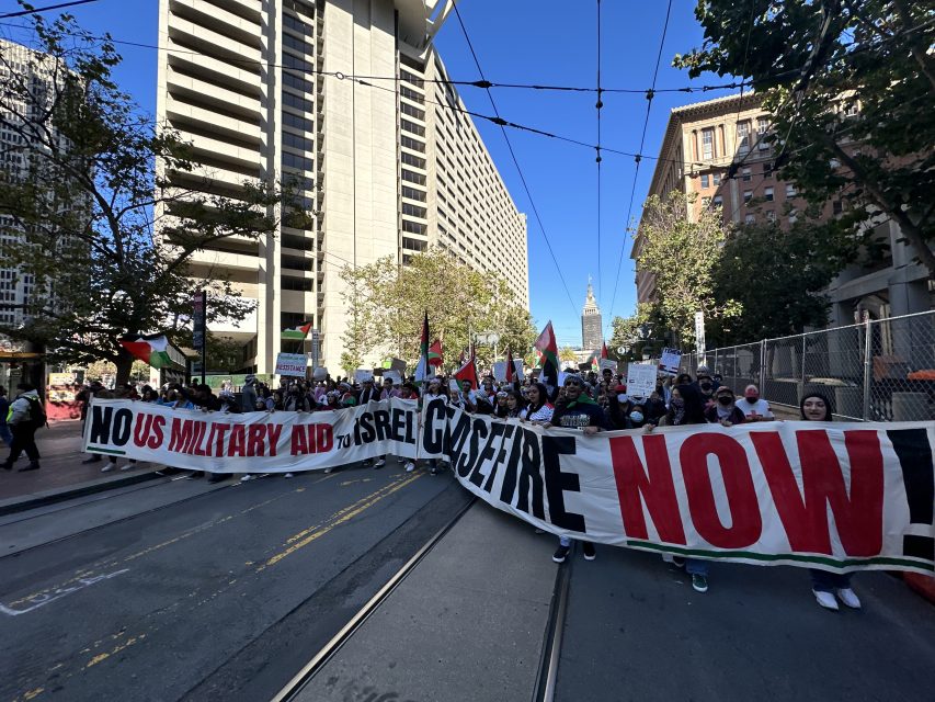 A group of people holding a banner reading "No US military aid to Israel, ceasefire now!"