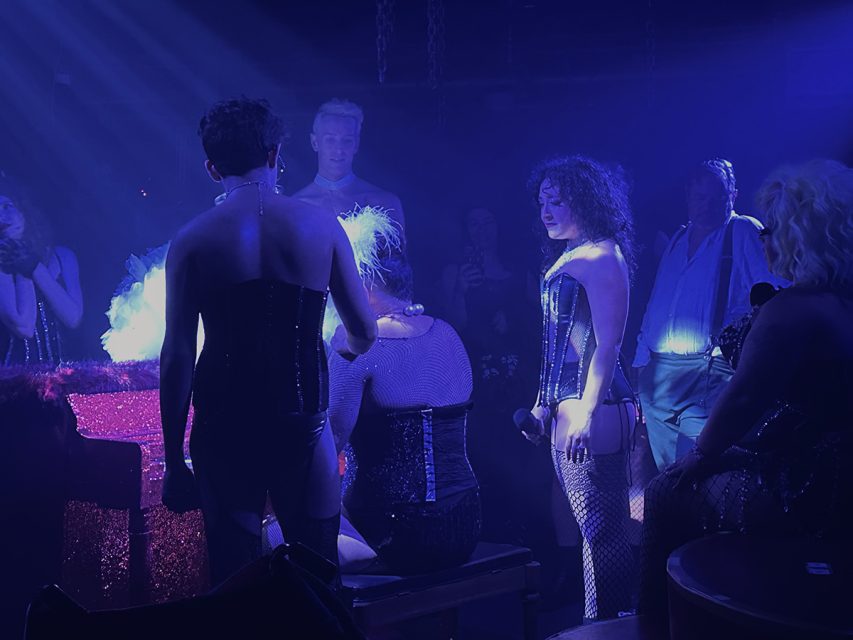 A group of people standing around a piano.