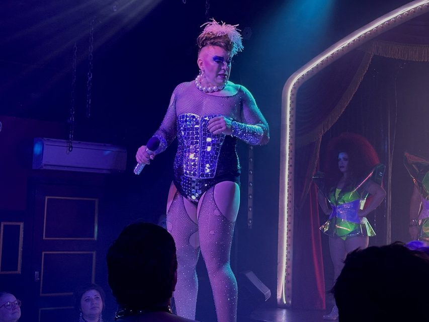 A woman in a costume on stage with other people.