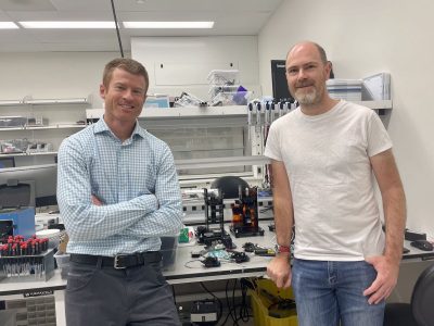 Two men standing next to each other in a lab.