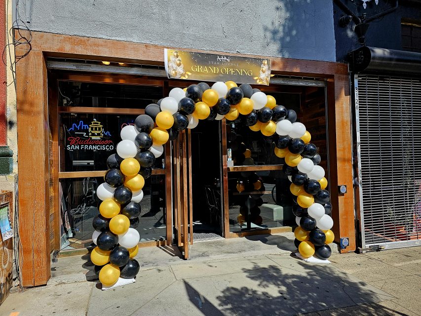 A black and gold balloon arch in front of the MN Star Lounge.