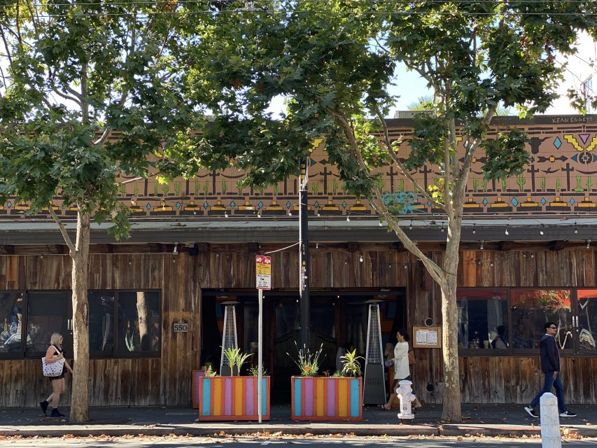 A wooden building with a tree in front of it.