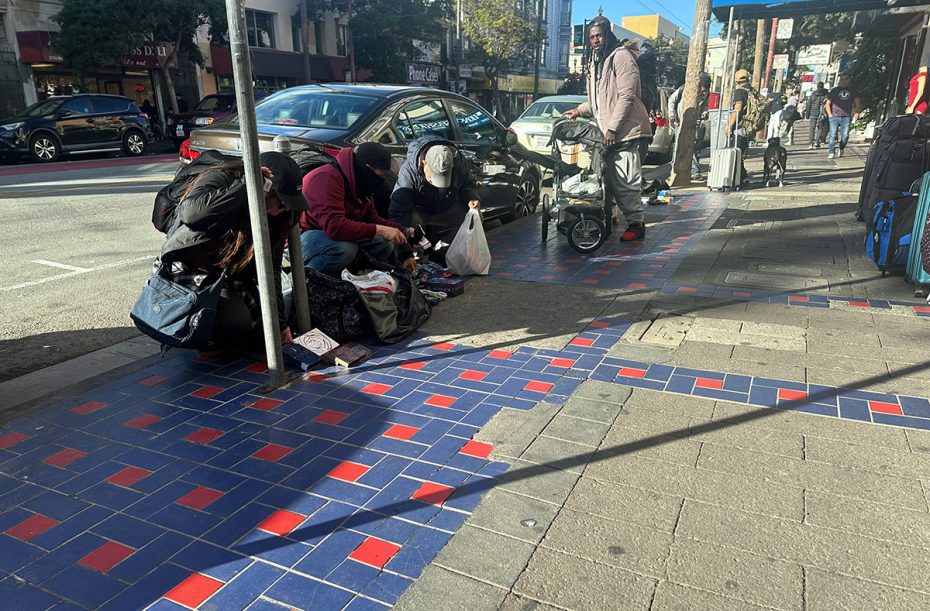 A red and blue tiled sidewalk with vendors