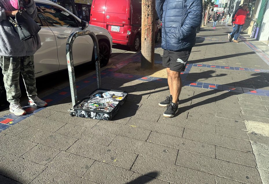 A group of people standing on a sidewalk.