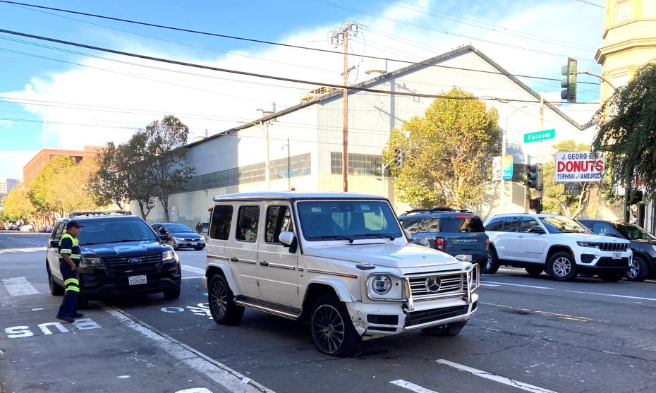 A white mercedes-benz car parked on a street.