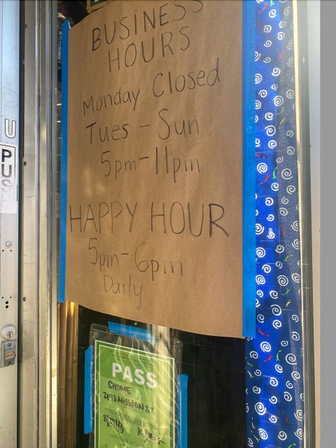 A sign on a door that says business hours monday closed happy hour.