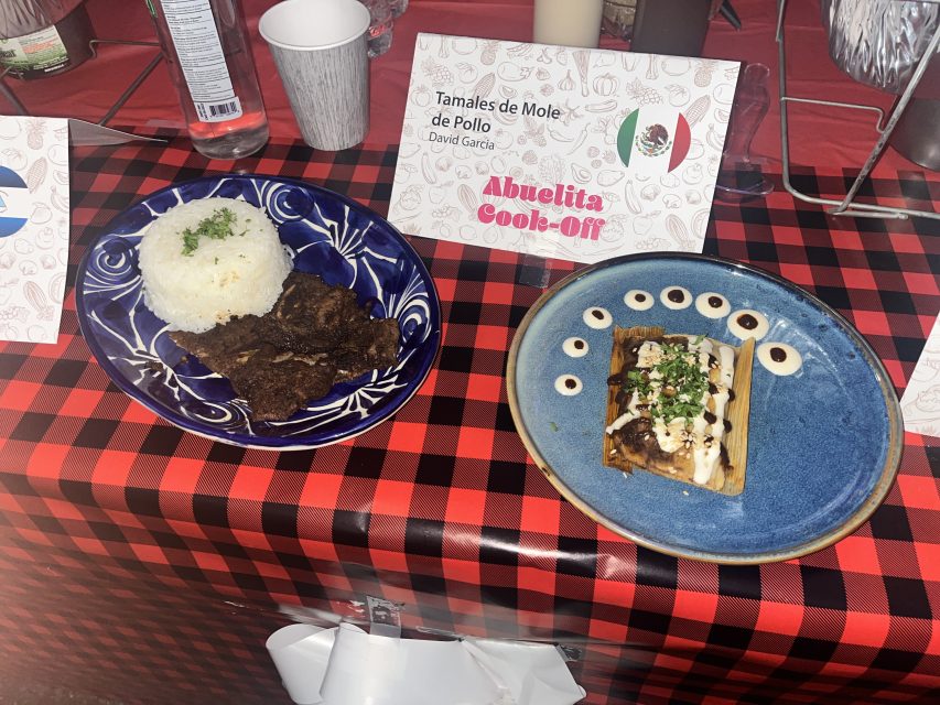 Two plates of food on a table. On the right is short-rib barbecue and on the left is mini tamales de mole de pollo. 