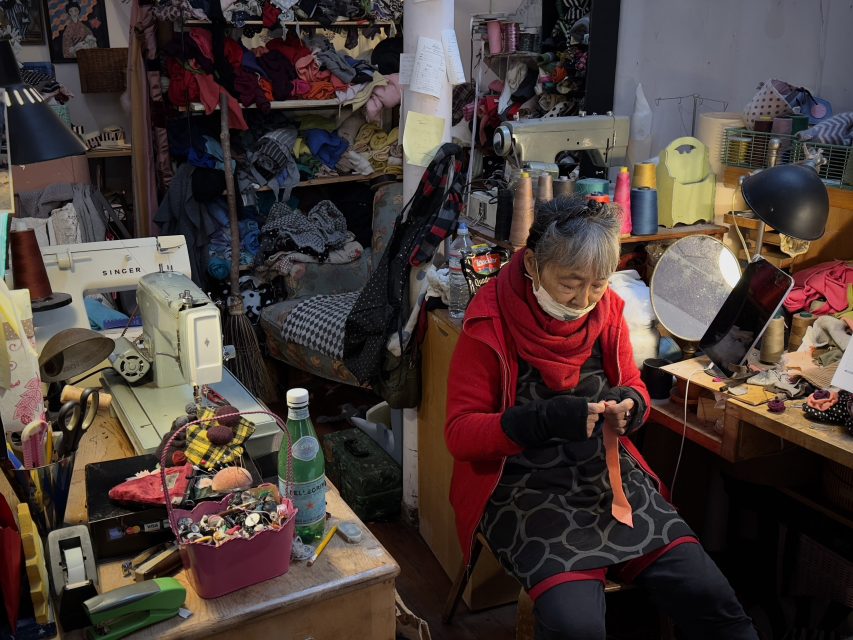 A woman working in a room full of fabrics