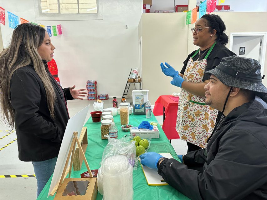 A group of people at a table talking to each other.